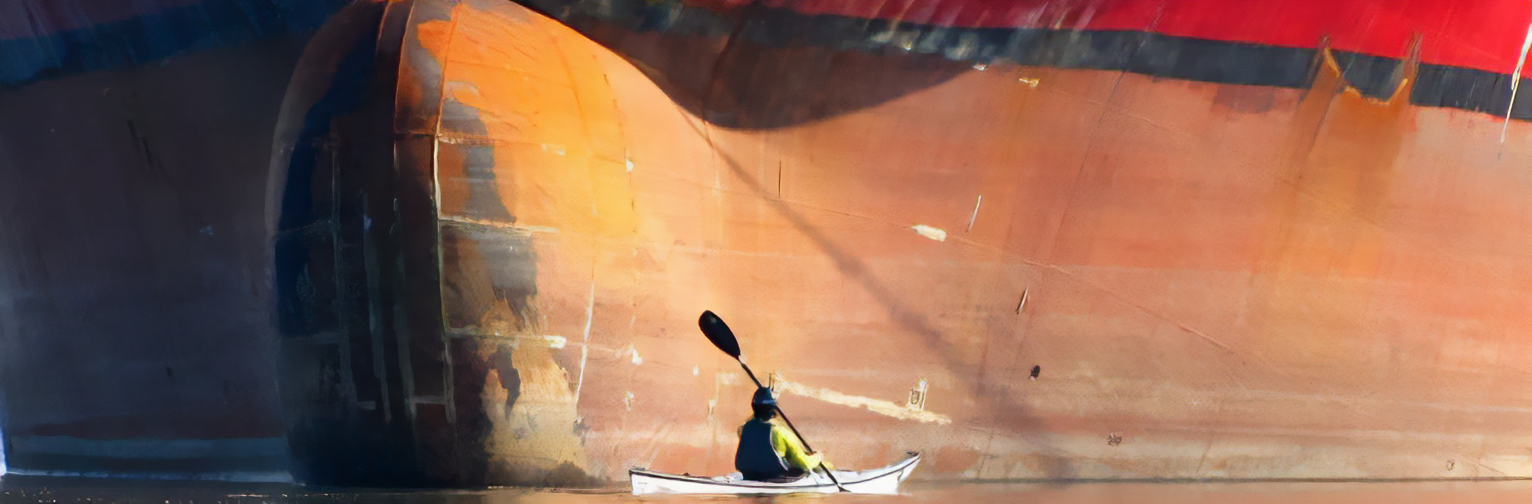 Kayaker Is dwarfed by a freighter